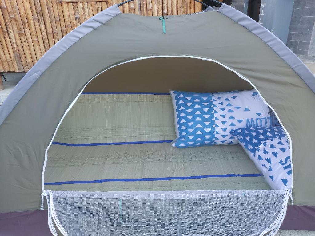 een bed in een tent met kussens erin bij Kua's Pad Batangas Tent in Calatagan