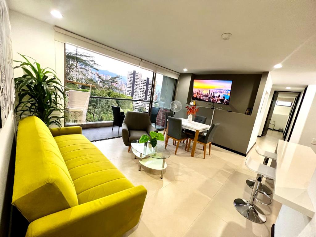 sala de estar con sofá amarillo y TV en Apartamento en unidad con Full Entretenimiento, en Medellín