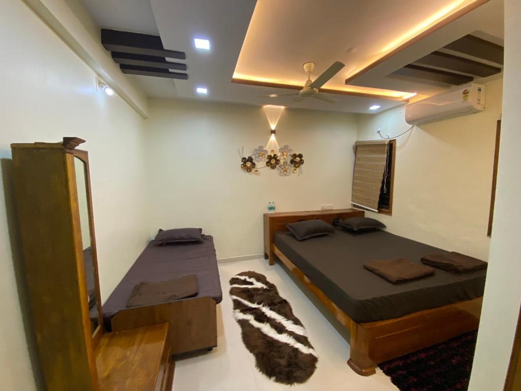a room with two beds and a mirror in it at AL-MANAL 306 Premium Room Triple Bed in Bhatkal