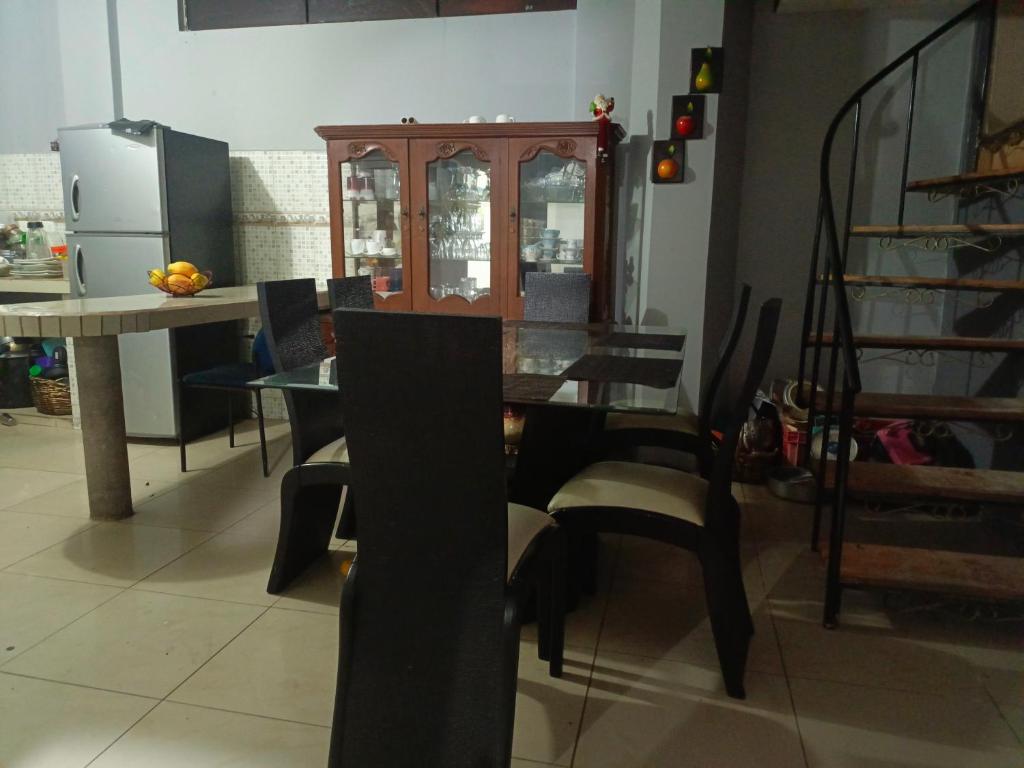 comedor con mesa de cristal y sillas en Acogedor apartamento en Píllaro, en Píllaro
