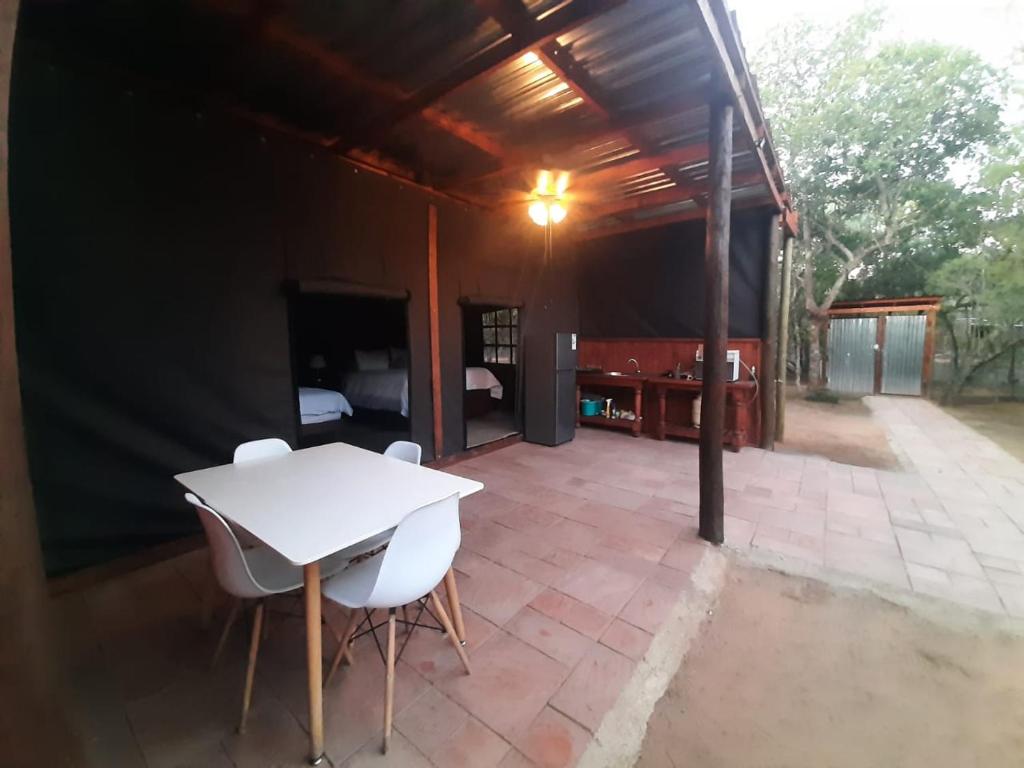 a patio with a white table and two chairs at VlakkiesKraal Bosbok Camp in Bela-Bela