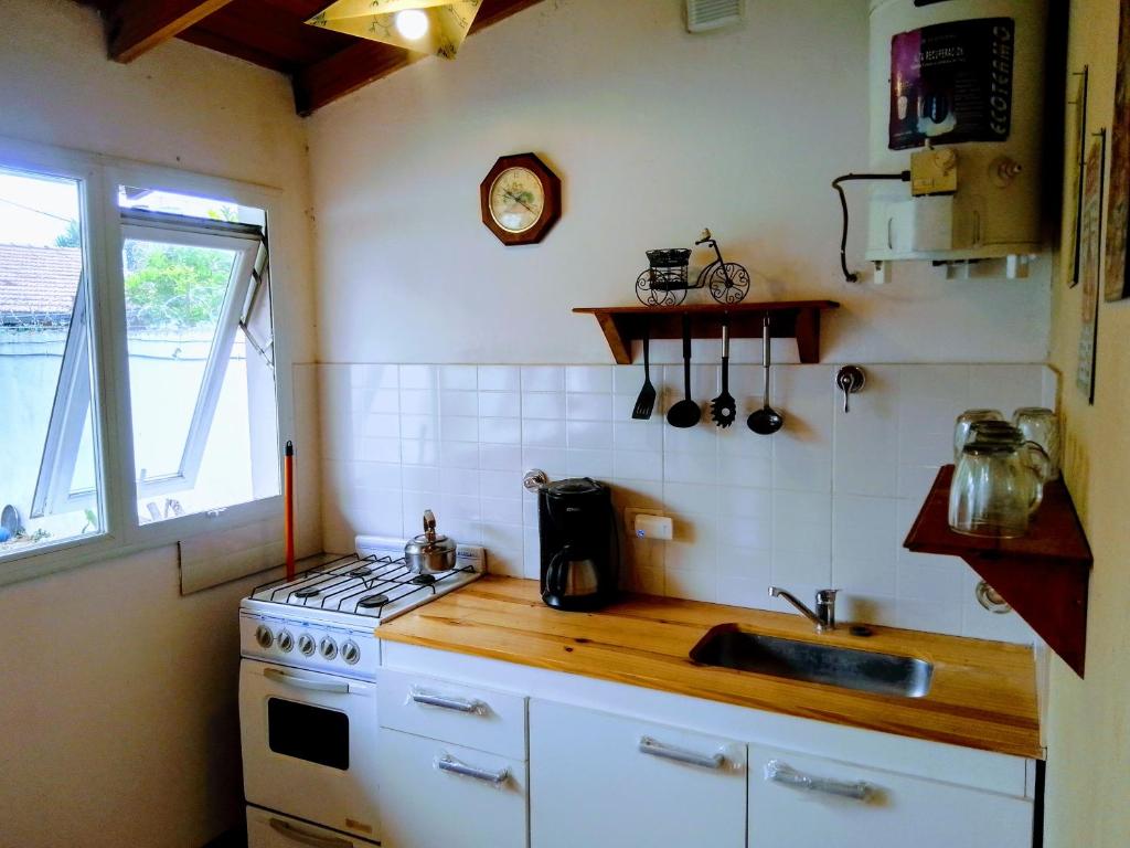 eine kleine Küche mit einer Spüle und einem Herd in der Unterkunft Dpto tipo cabaña a 3 cuadras del mar in Mar del Plata