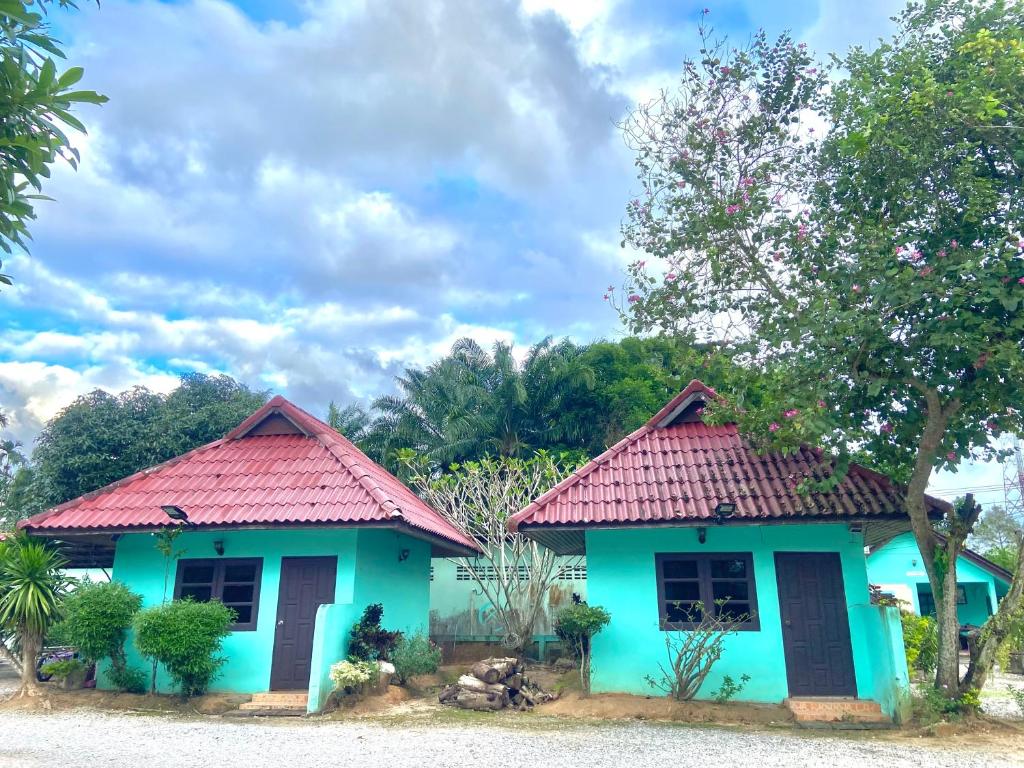 Thungtako Resort في Ban Samnak Pling: منزل ازرق صغير بسقف احمر