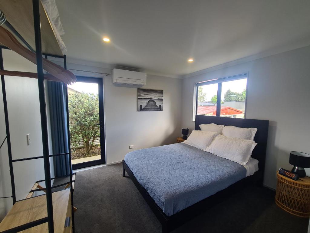a bedroom with a bed and a large window at Bonnie Doone in Te Awamutu