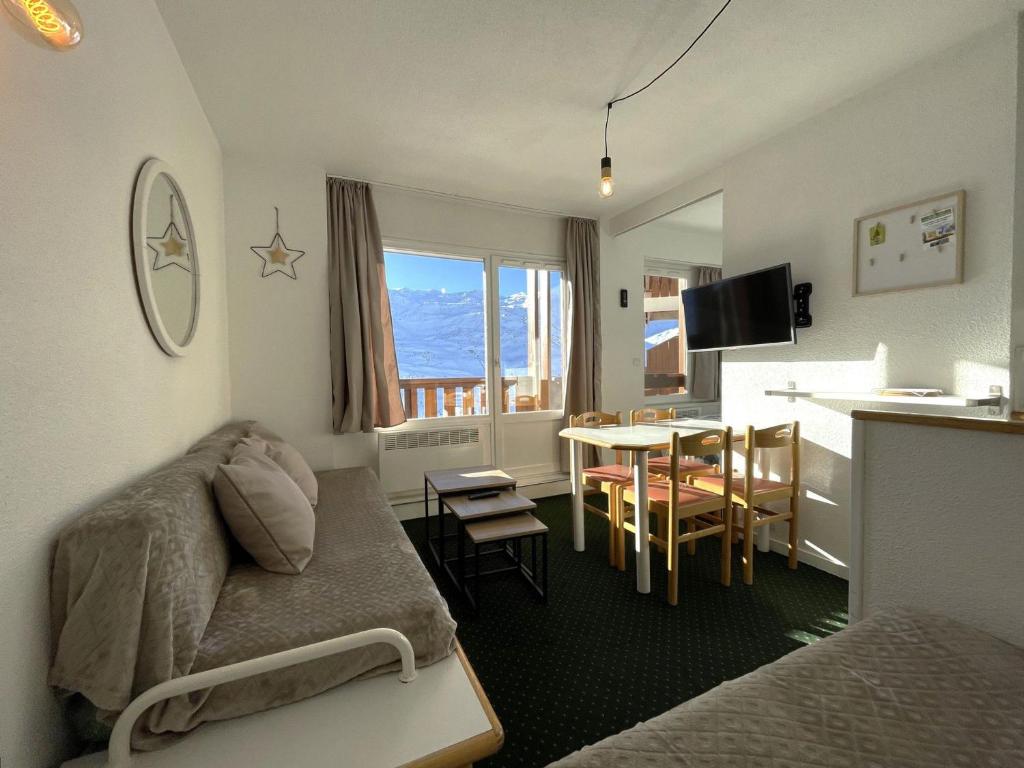 un salon avec un canapé et une table et une cuisine dans l'établissement Appartement 4 pers avec chambre, casier à skis, balcon, Les Menuires - FR-1-452-387, aux Menuires