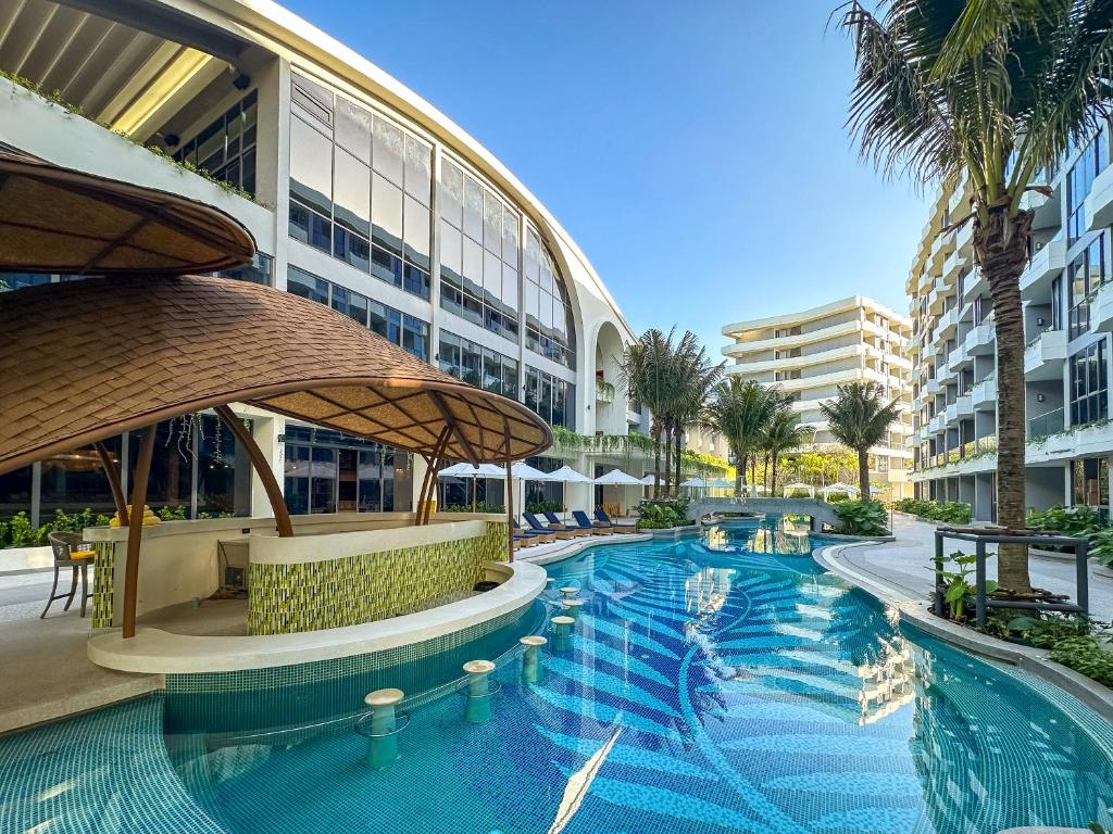 a swimming pool in a resort with a large building at La Green Hotel and Residence in Bang Tao Beach