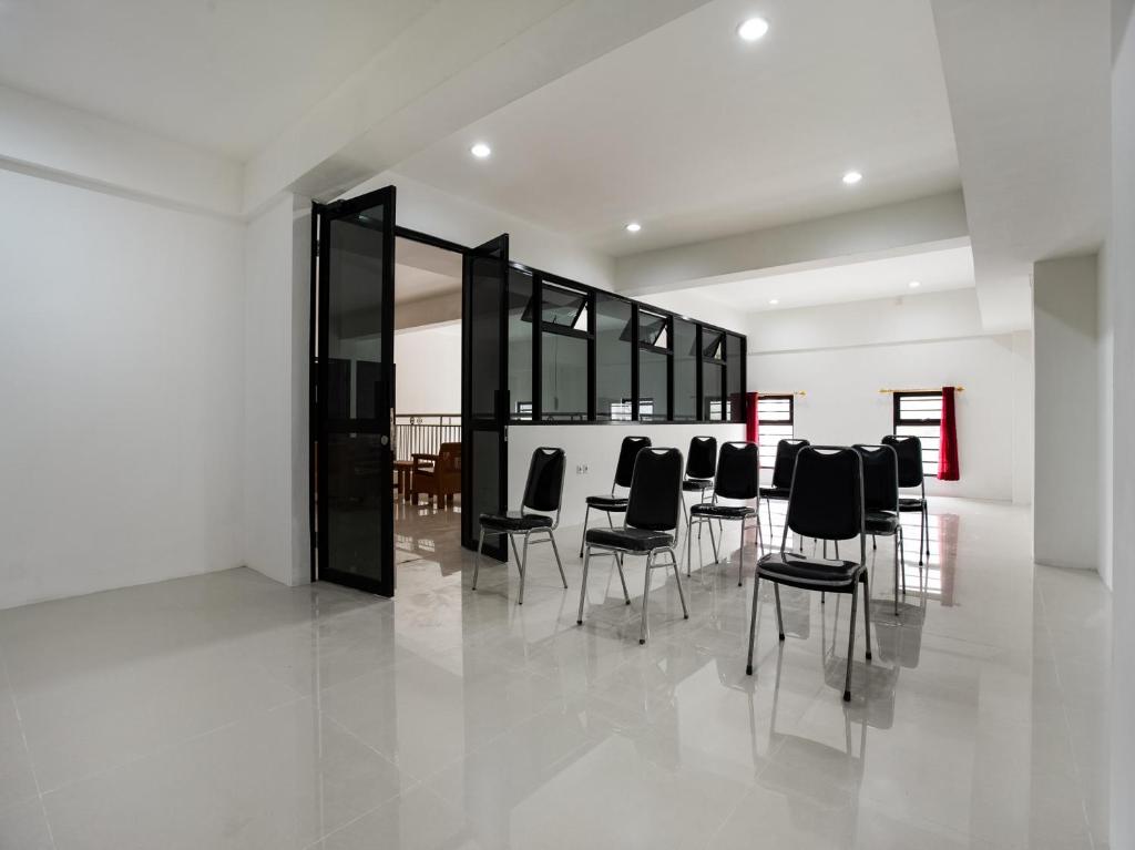 een groep zwarte stoelen in een witte kamer bij Super OYO Capital O 3463 Cimahi Guest House in Bandung