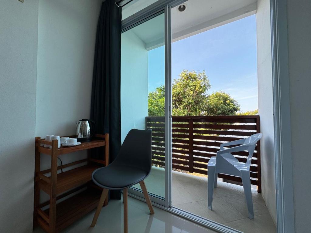 a chair and a desk in a room with a window at Sleep inn Samui in Choeng Mon Beach