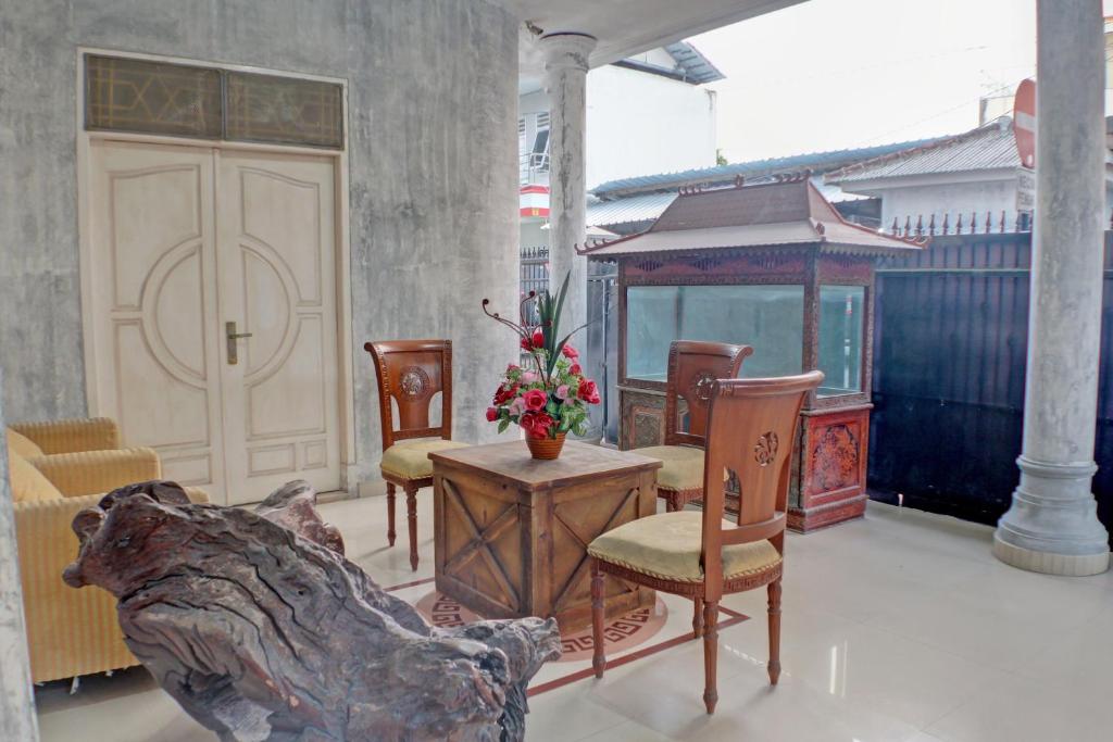 - une terrasse couverte avec des chaises, une table et une porte dans l'établissement SPOT ON 92834 Wisma Dira Tiara Syariah, à Lampung