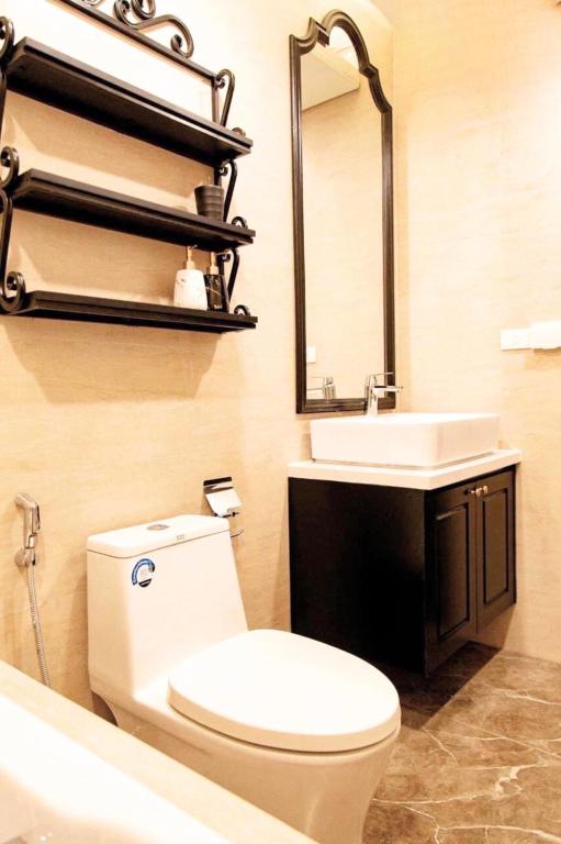 a bathroom with a toilet and a sink and a mirror at FLC Luxury Apartment Quy Nhon in Quy Nhon