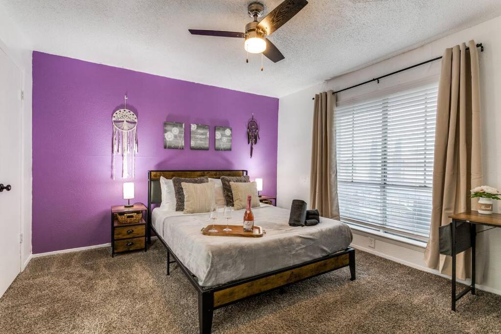 a bedroom with purple walls and a bed with a table at Medical District_Fast Wi-fi in Dallas