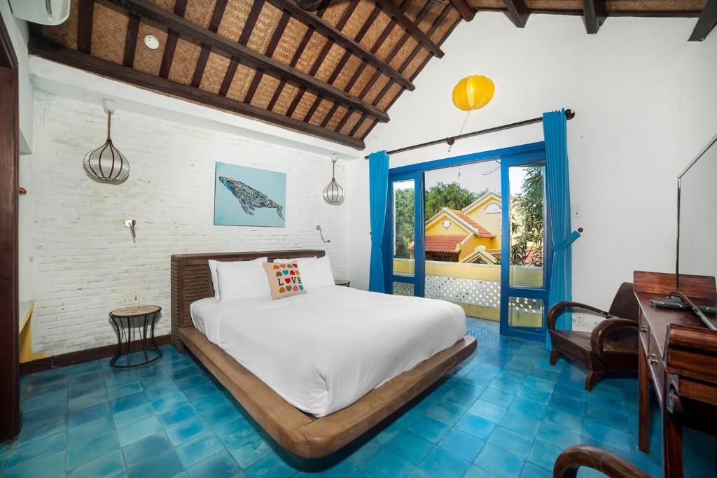 An Bàn (2)にあるLoft House 2BR Beachside An Bang Beach Hoi An by Beachside Boutique Homesのベッドと机と窓のある寝室