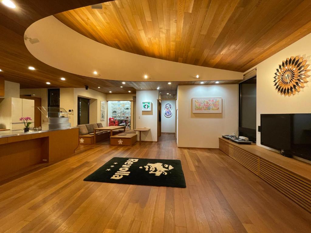 Makinohara的住宿－Villa Revo Shizuoka Japan，厨房以及带电视和地毯的客厅。