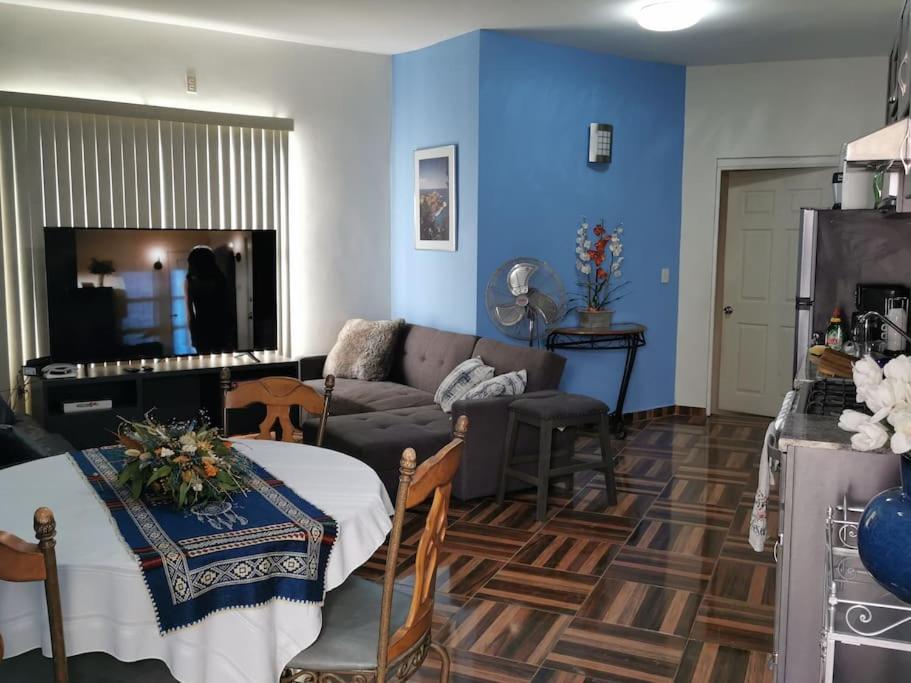 a living room with a couch and a table at Departamento El Muro Azul in Tijuana