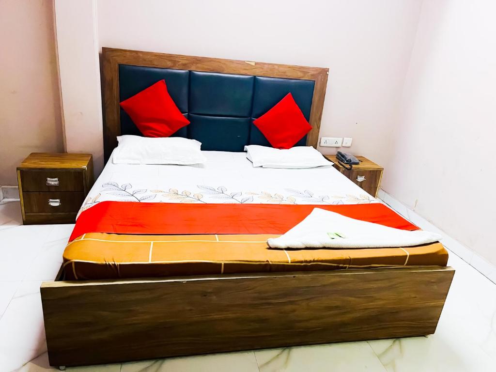 a bedroom with a large bed with red pillows at Sunrise Haven Near Nizamuddin Railway Station 2 Min Walk in New Delhi