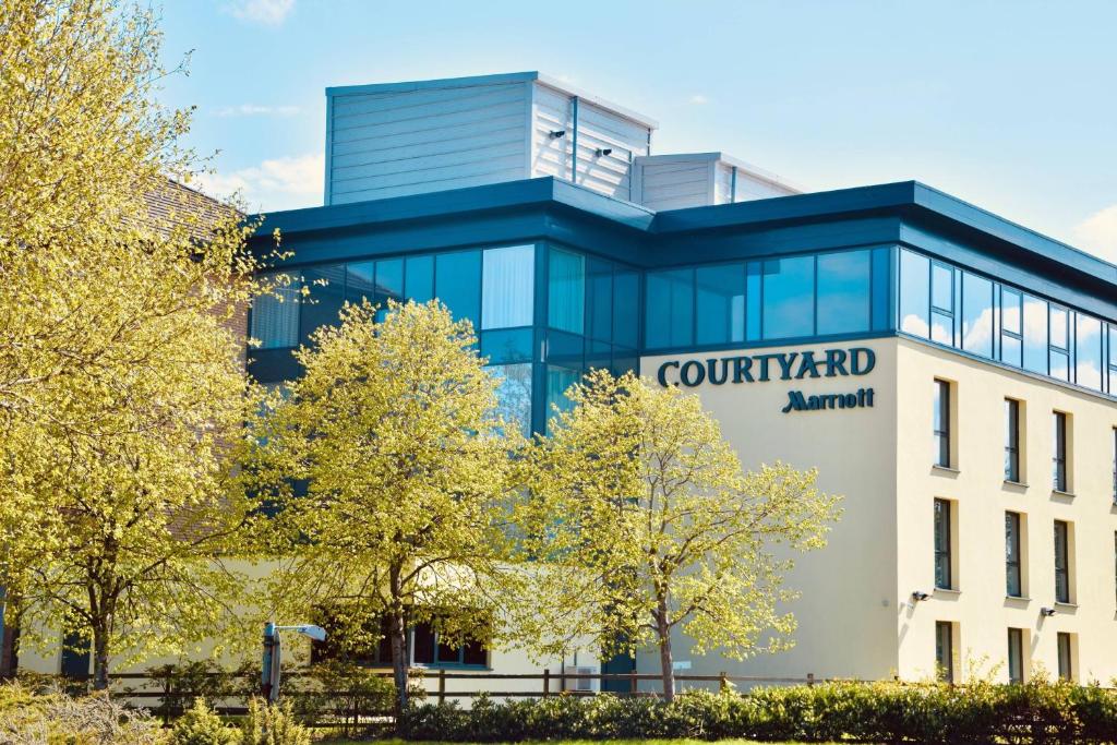 Courtyard by Marriott Glasgow Airport في بيزلي: مبنى مع أتريوم ساحة الفناء