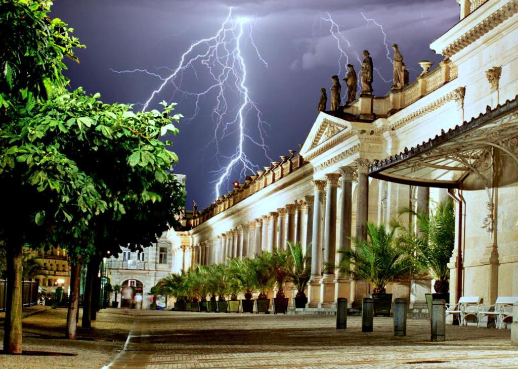 a lightning storm over a building at night at Angel's Apartment in Karlovy Vary