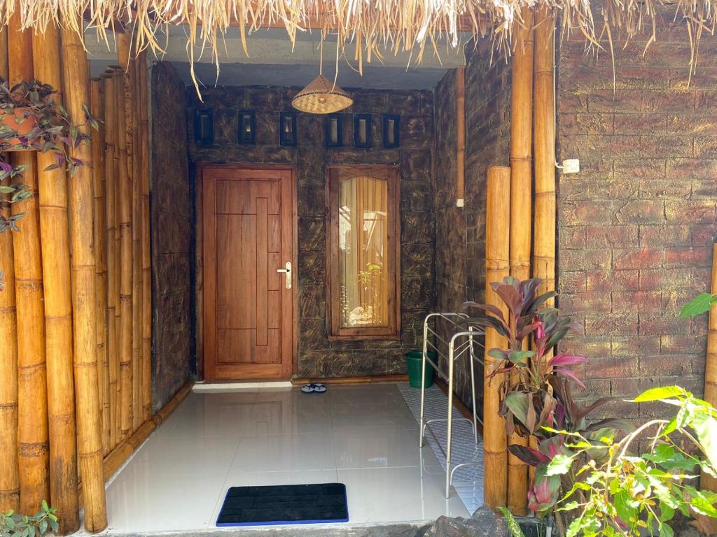 - un couloir d'une maison avec une porte en bois dans l'établissement Dira Bungalows, à Tetebatu