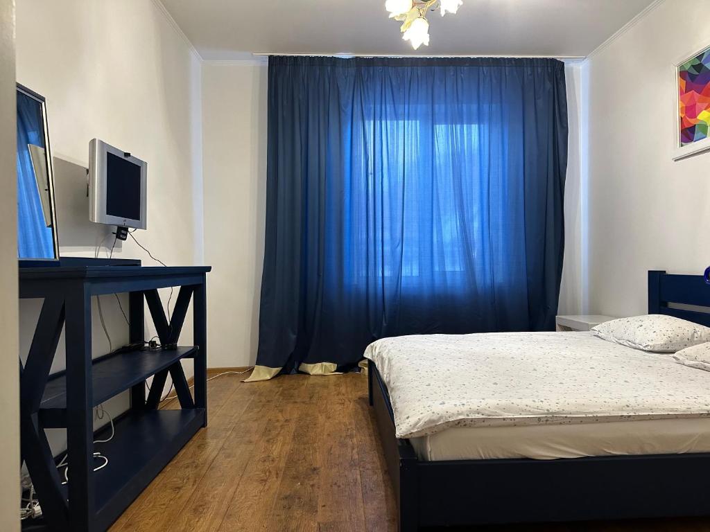 een slaapkamer met een bed en een blauw gordijn bij Guculka in Jaremtsje