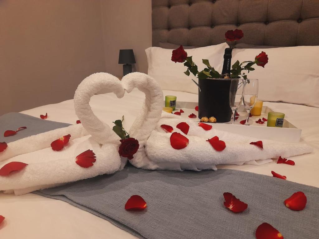 duas toalhas em forma de cisnes sentadas numa cama com corações em 51 On Vlei na Cidade do Cabo
