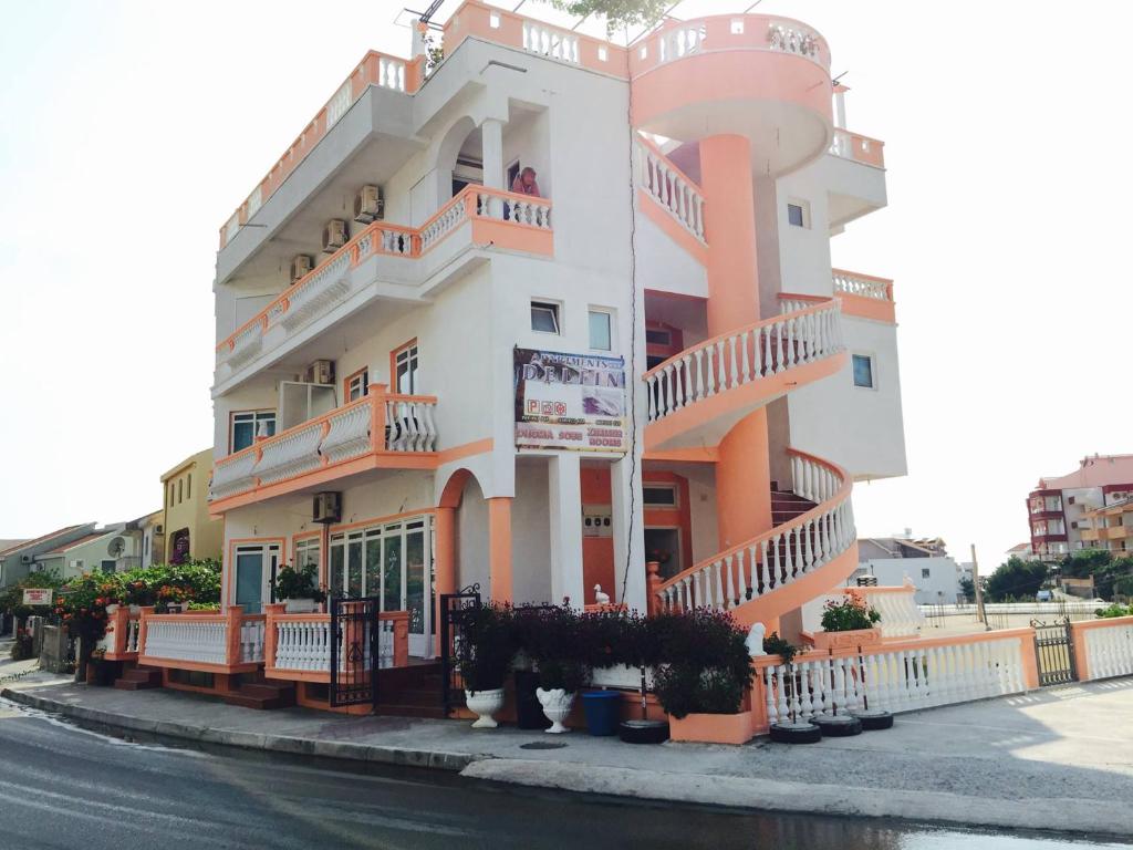 a large white building with balconies on a street at Apartments Delfin in Ulcinj