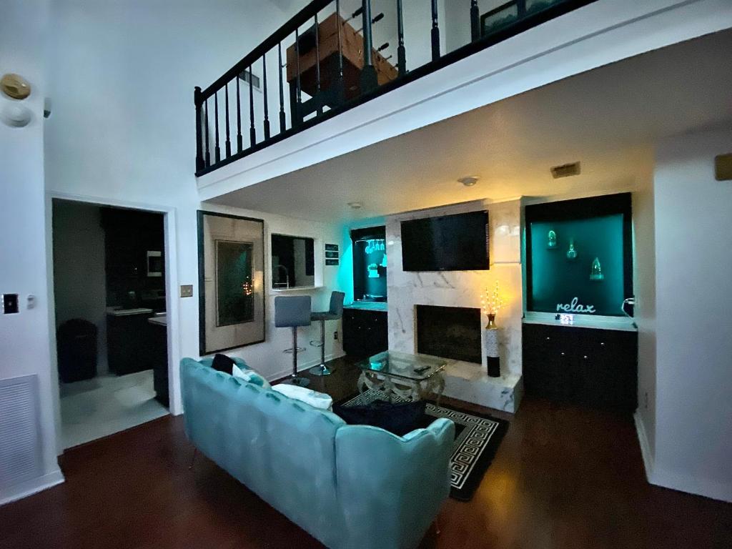 a living room with a blue couch and a staircase at Elegant Parisian Home near Fondren in Jackson