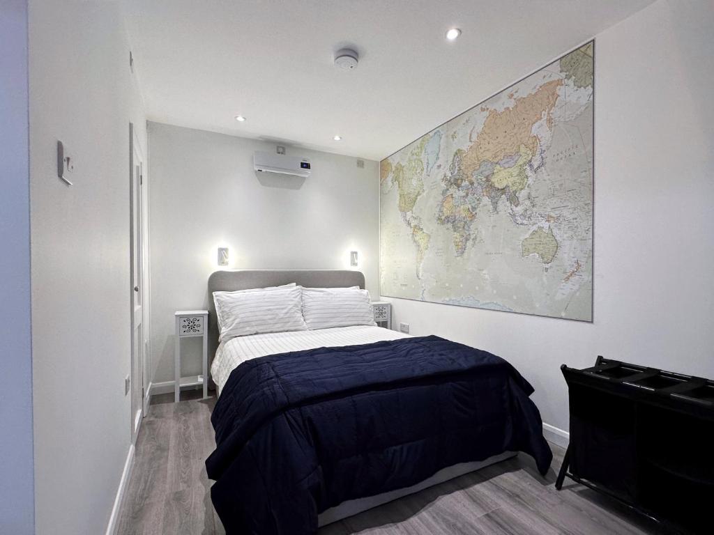 1 dormitorio con 1 cama y un mapa en la pared en Kensington Studio hosted by AirOperate near Notting Hill - 1 Double Bed , 1 Sofa Bed, Ground Floor Apartment via Private Entrance en Londres