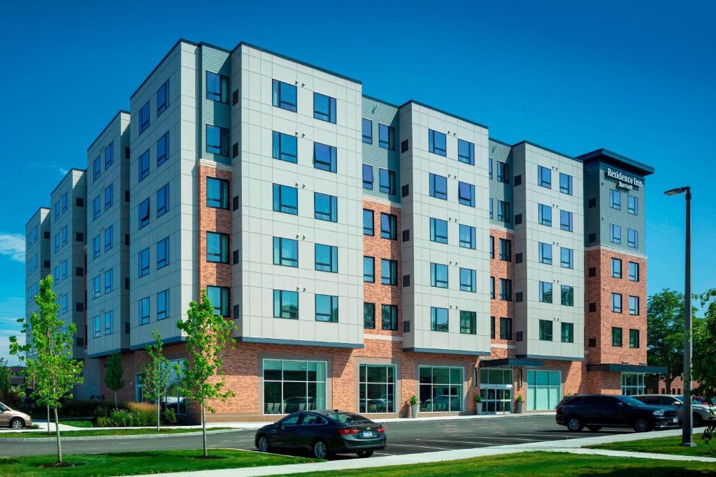 un grand bâtiment avec des voitures garées devant lui dans l'établissement Residence Inn by Marriott Boston Burlington, à Burlington