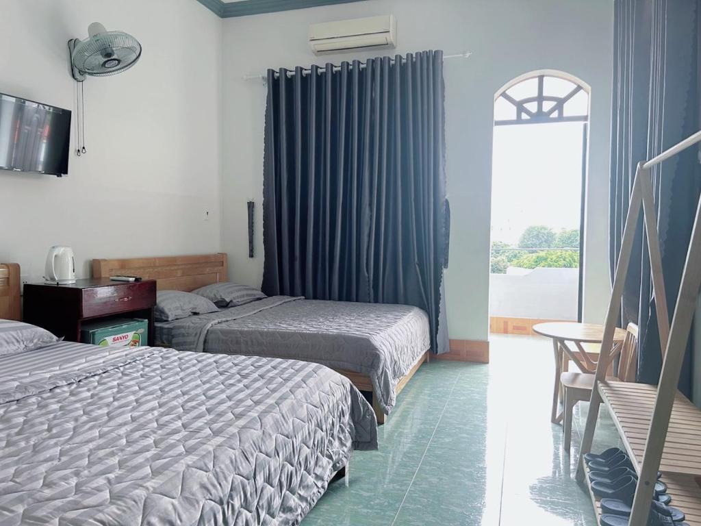 a hotel room with two beds and a window at Hotel Minh Vy in Long Hai