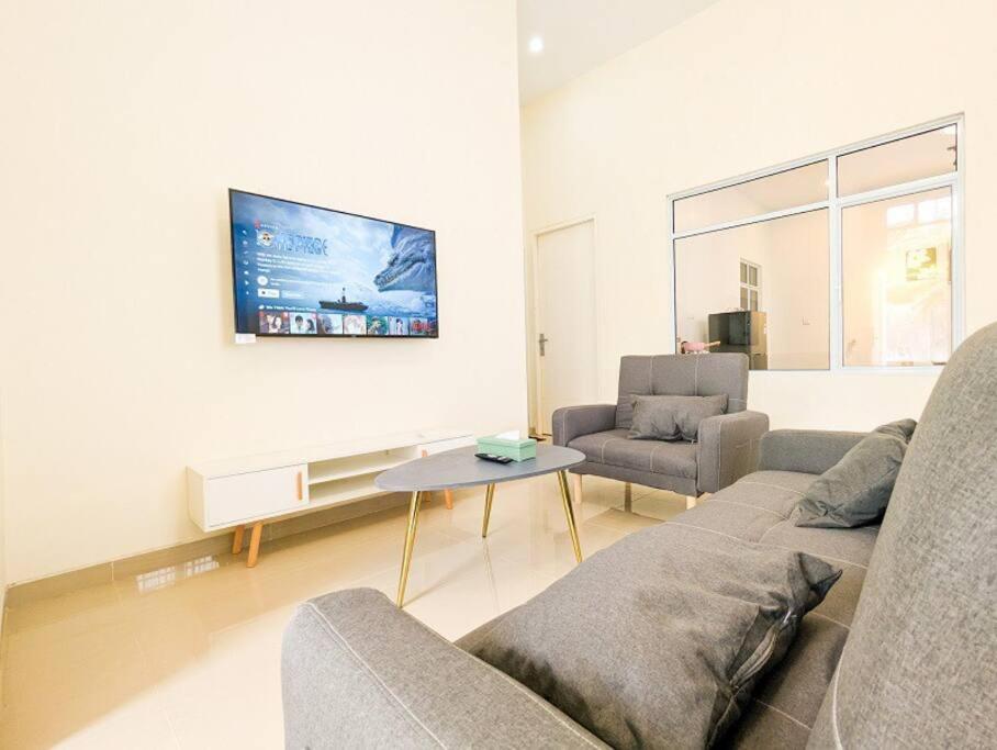 uma sala de estar com um sofá e uma mesa em Lovina B2/12A at Ansley Park Spacious+Netflix em Batam Center