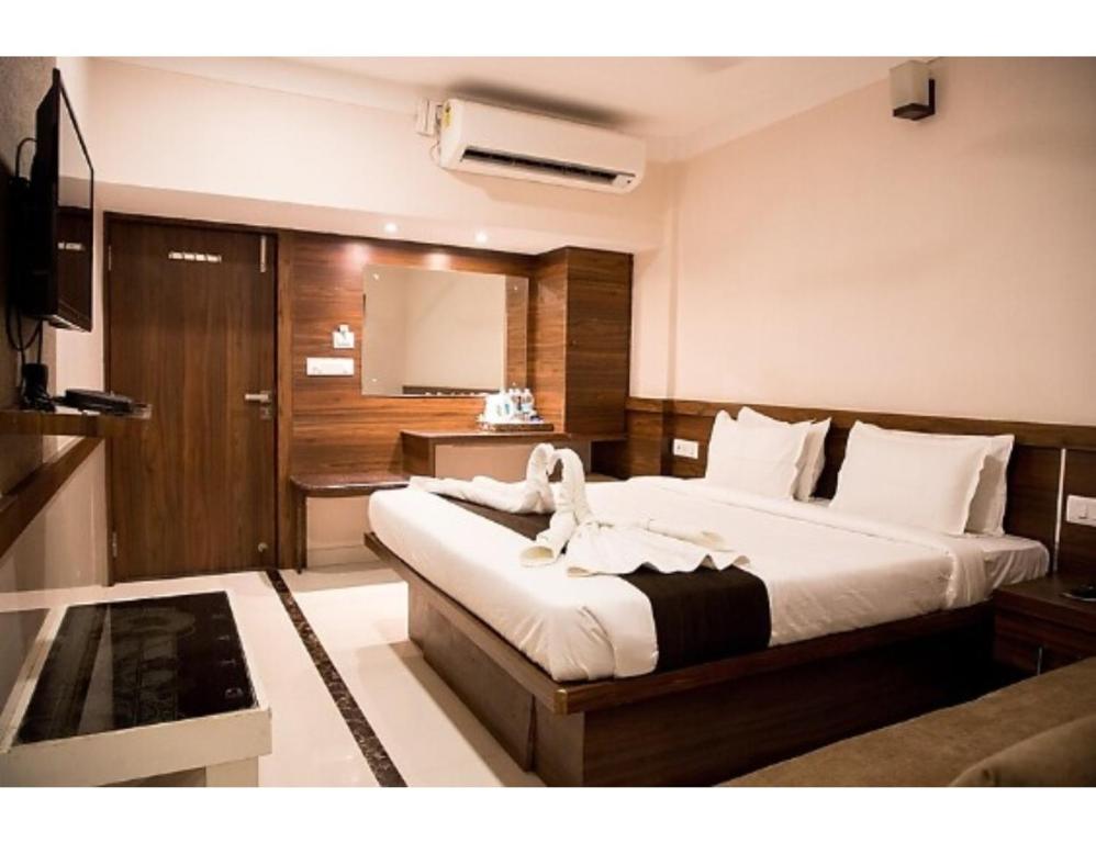 1 dormitorio con 1 cama grande y TV en Hotel Paras, Jabalpur, en Jabalpur