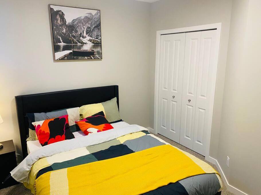 - une chambre dotée d'un lit avec des oreillers colorés dans l'établissement Newly built 2 Bedroom apartment, à Calgary