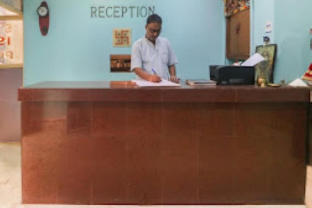 a woman standing at a counter in a store at Hotel Maitry,Cuttack in Cuttack