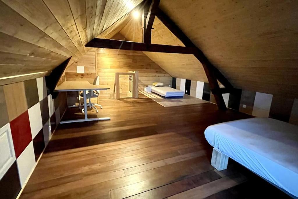 ImphyにあるAMELIE 1 Chambre 3 lits 2 à 5 personnesのベッドとデスクが備わる屋根裏部屋です。
