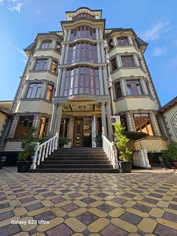 a large building with stairs in front of it at Hotel Sharq in Dushanbe