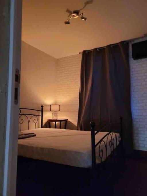 1 dormitorio con 1 cama con marco negro en Appartement calme et chaleureux, en Tours