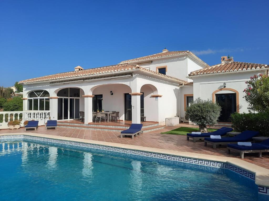 uma villa com piscina em frente a uma casa em Casa Solanum em Frigiliana