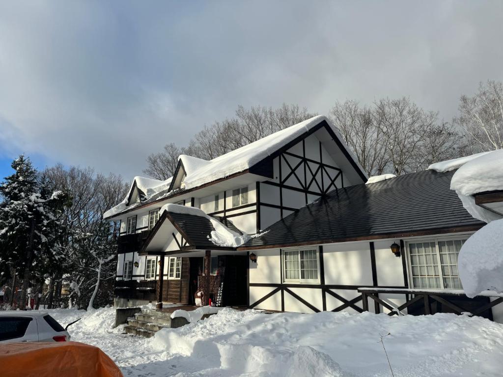 una casa está cubierta de nieve en ALBERGO DEL PESCATORE en Minamiaizu