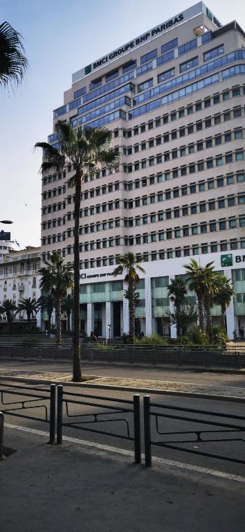a large building with palm trees in front of it at LE BONHEUR in Casablanca