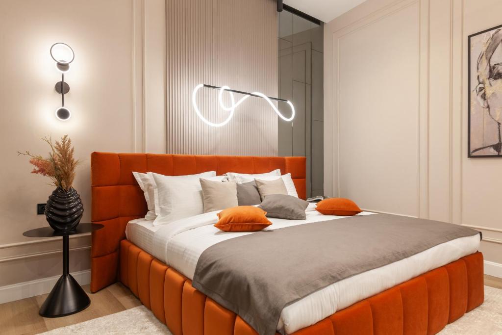 リヴィウにあるAlfa Apartments Ivana Frankaのベッドルームにオレンジのヘッドボード付きのベッド1台