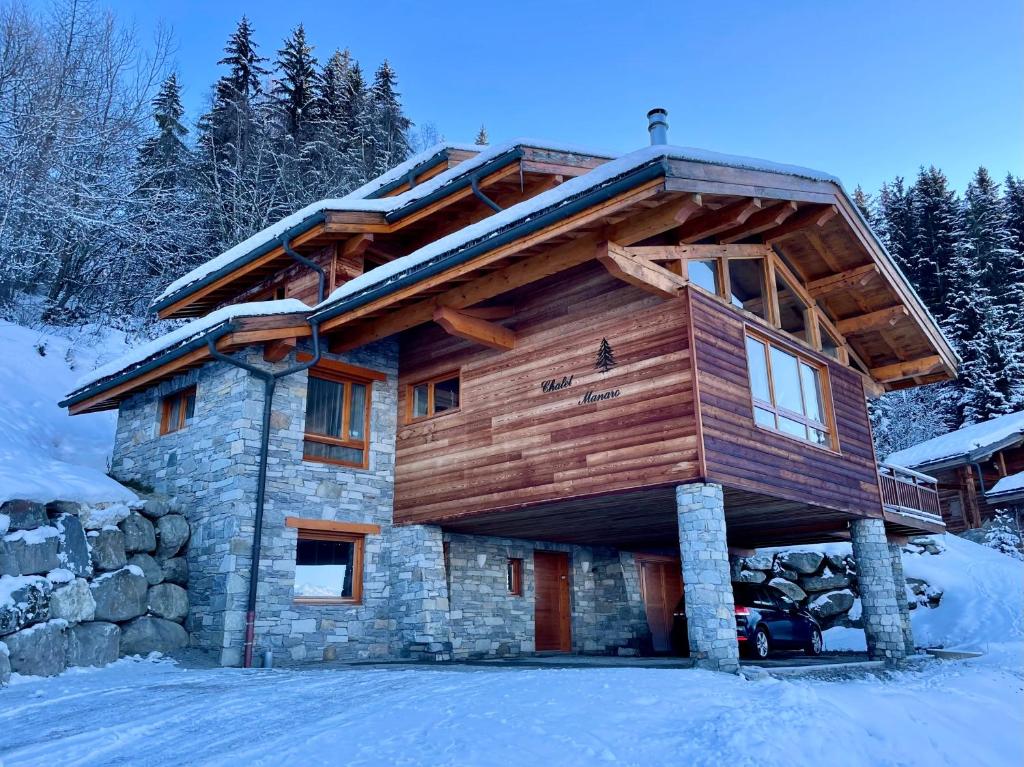 a log cabin in the snow with snow at Arc 1800, le Chalet Manaro avec sa vue panoramique in Bourg-Saint-Maurice