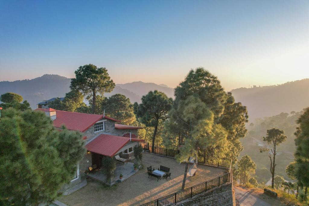 an aerial view of a house with a fence and trees at SaffronStays The Perch in Kasauli
