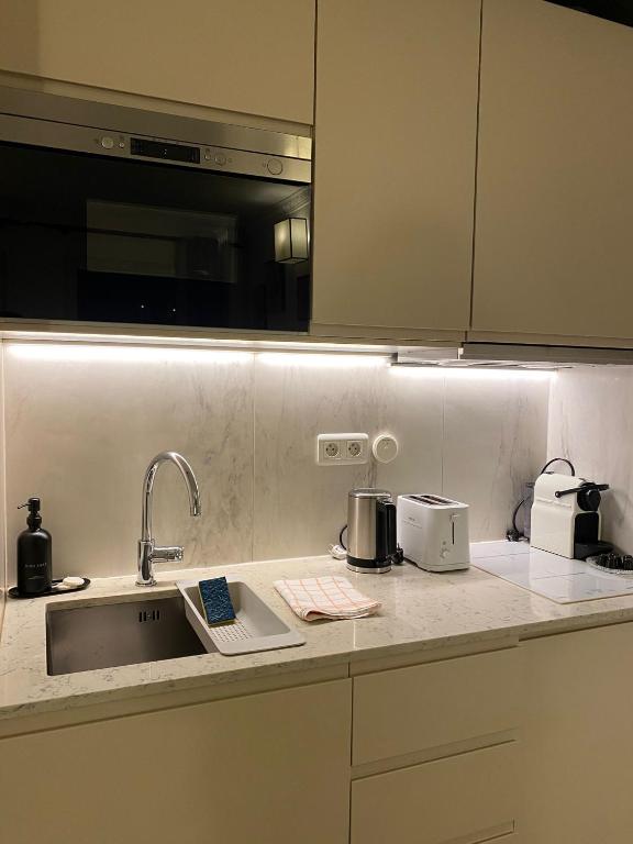 a kitchen with a sink and a counter top with appliances at Cozy studio 10 min from Eiffel Tower Invalides Beaugrenelle in Paris