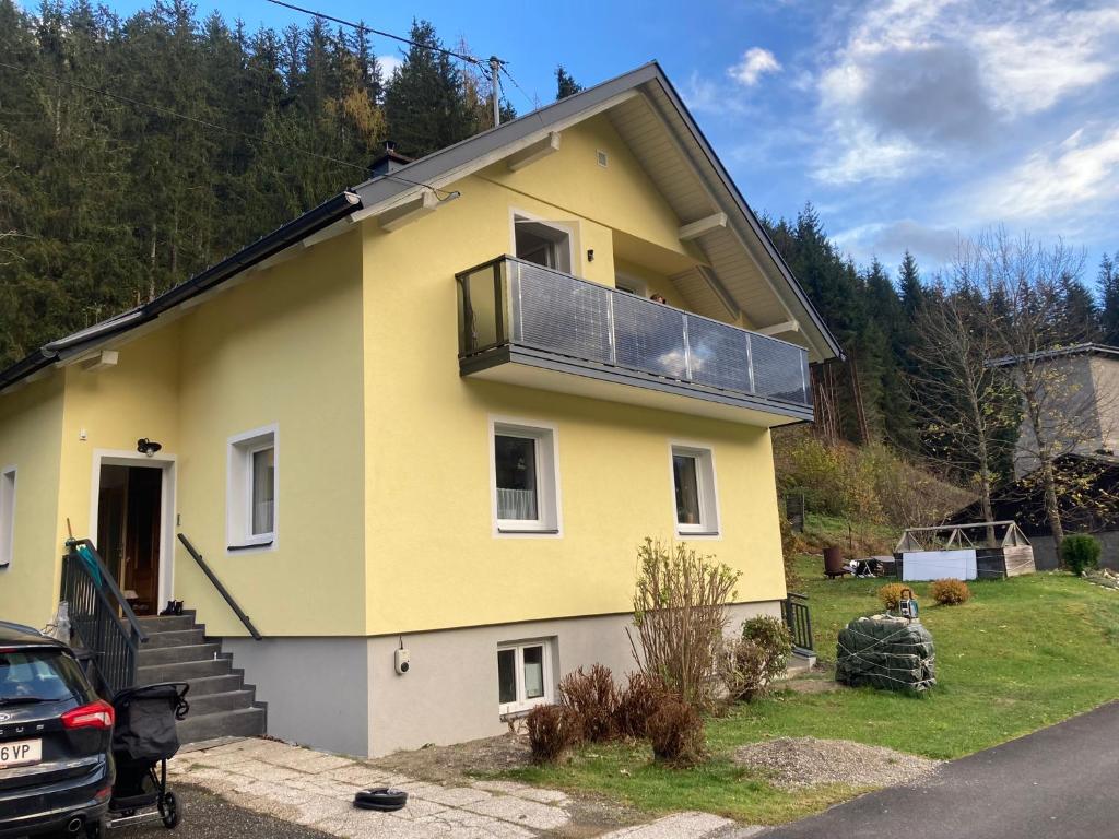 Una casa amarilla con balcón en la parte superior. en Sonja´s Ferienwohnung, en Patergassen