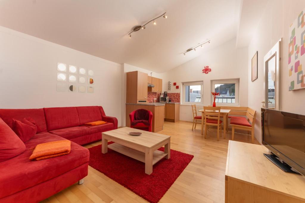 a living room with a red couch and a table at Appartements Maria Stewart by Schladming-Appartements in Schladming