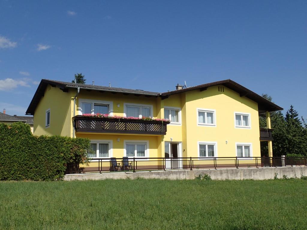 ein gelbes Haus mit einem Zaun davor in der Unterkunft Relax & Therapy in Bad Tatzmannsdorf