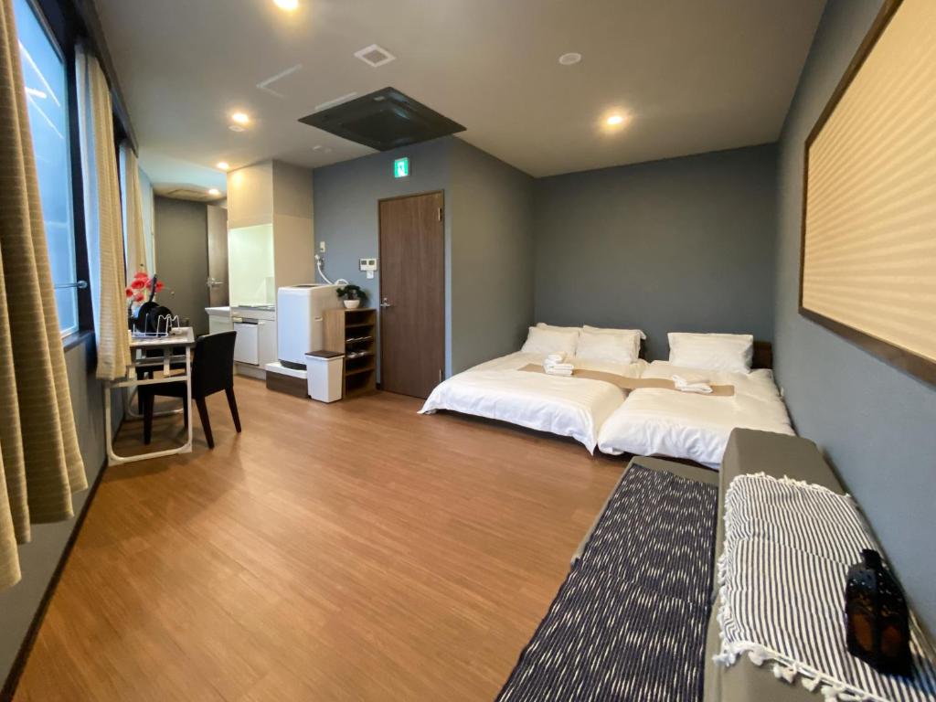 1 dormitorio con 2 camas y escritorio. en Tomi Home 2F, en Tokio