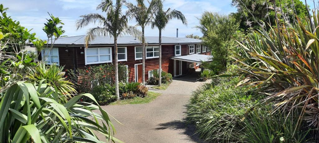 a house with a pathway in front of it at The Waiheke Lodge in Onetangi