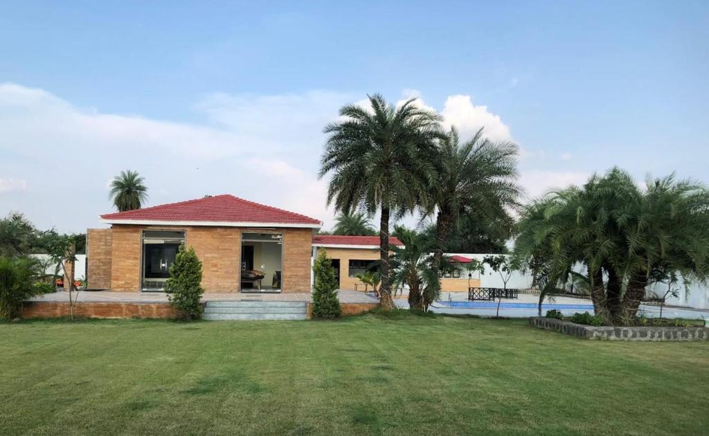 a house with palm trees and a yard at Kadwali Villa with Private Pool in Ujjain