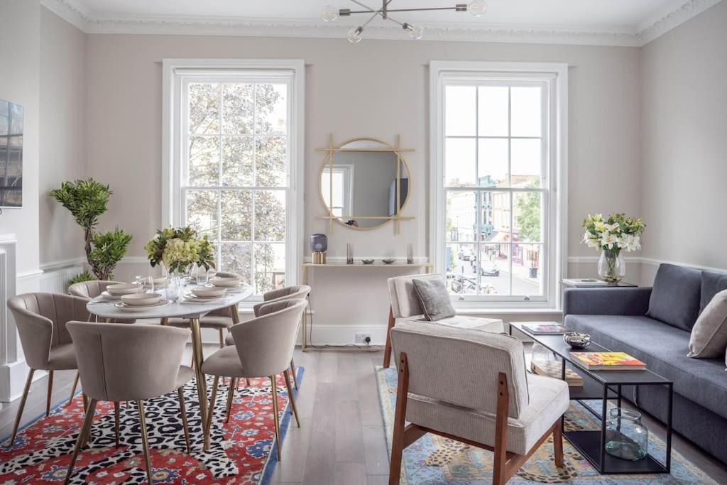 een woonkamer met een tafel en een blauwe bank bij Spectacular flat located in prime Notting Hill in Londen